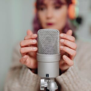 Girl tapping microphone wearing headphones
